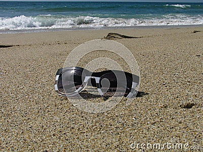 Women's sunglasses isolated on a sandy ocean beach Stock Photo
